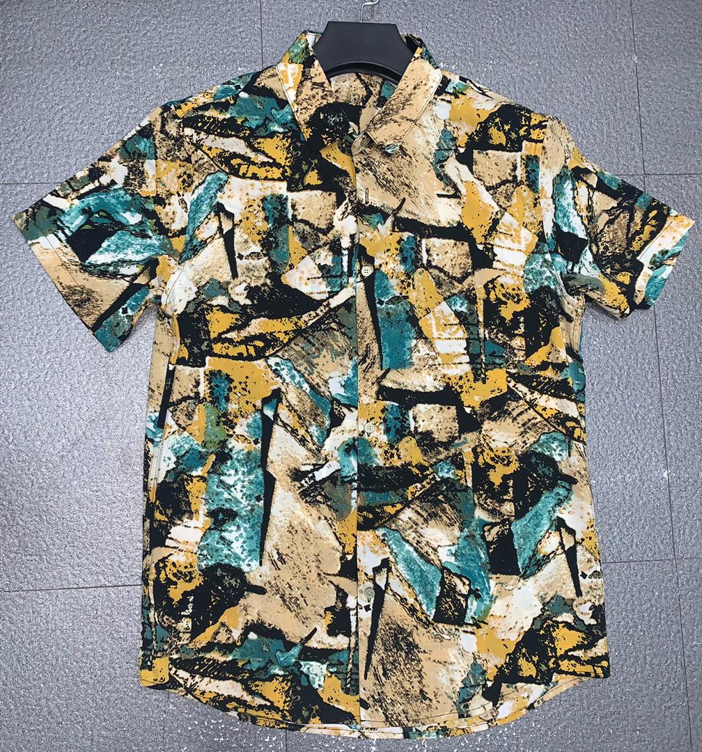 Zara Short-Sleeved Button-Up shirt With an abstract Pattern in Shades of Yellow, Black, Tan, and Teal.